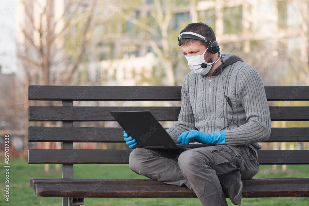 man in mask and gloves using laptop outdoors man in mask and gloves using laptop outdoors