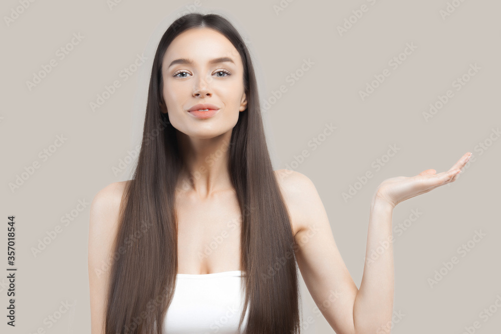 Young beautiful woman with clean perfect skin demonstrates goods in palm of your hand Young beautiful woman with clean perfect skin demonstrates goods in palm of your hand