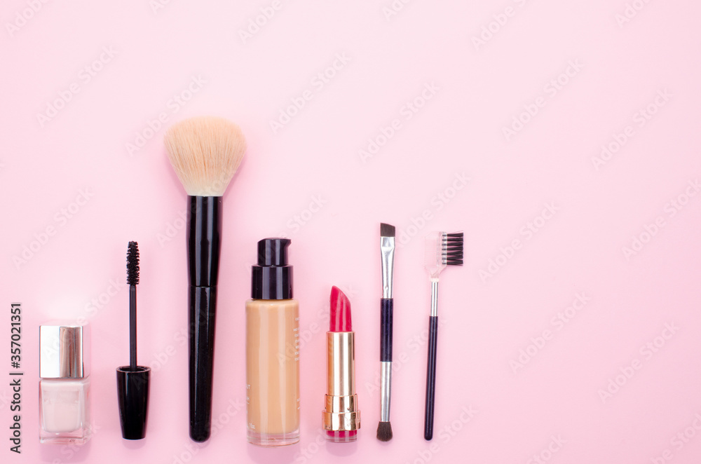 Makeup accessories on a pink background located at the bottom left of the image. Makeup accessories on a pink background located at the bottom left of the image.