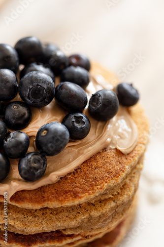 Oatmeal pancakes topped with hazelnut paste and blueberries