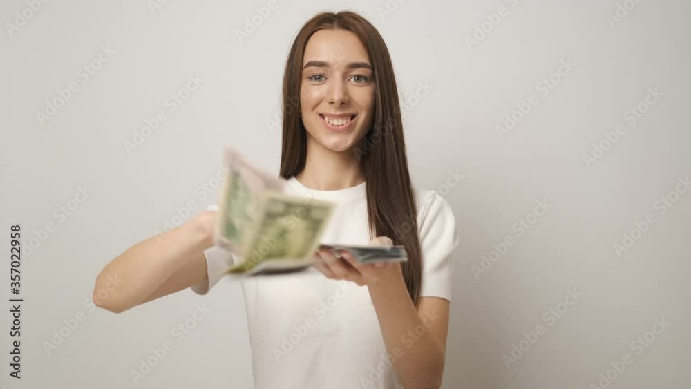 Rich and beautiful business successful woman with a beautiful smile scattering money 100 dollar bills. Salary. Happy worker Rich and beautiful business successful woman with a beautiful smile scattering money 100 dollar bills. Salary. Happy worker