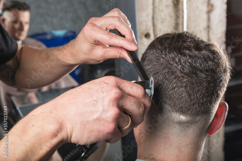 hombre peluquero cortando el pelo a cliente © Néstor Rodan
