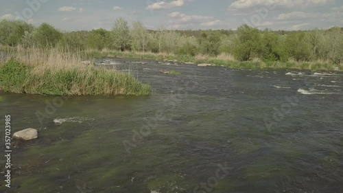 Aerial view to granite mountains and rapids on Southern Bug river, surrounded by trees and grasses, Mihiia village. Ukraine. Famous place for rafting and kayaking photo