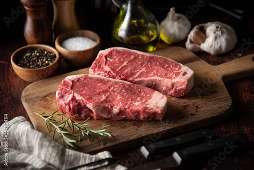 raw strip beef steak meat on wooden cutting board
