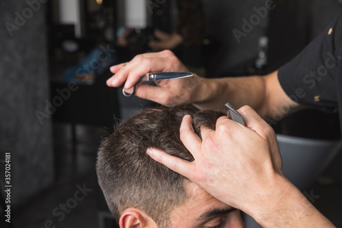 hombre peluquero cortando el pelo a cliente