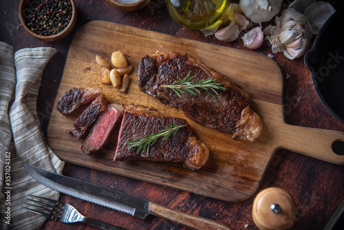 dark image of sirloin beef steak on wooden board photo