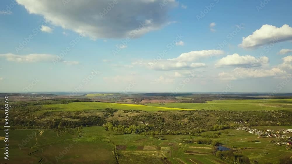Aerial view of pathed plowed farm fields and distant village houses in spring. Aerial view of pathed plowed farm fields and distant village houses in spring.