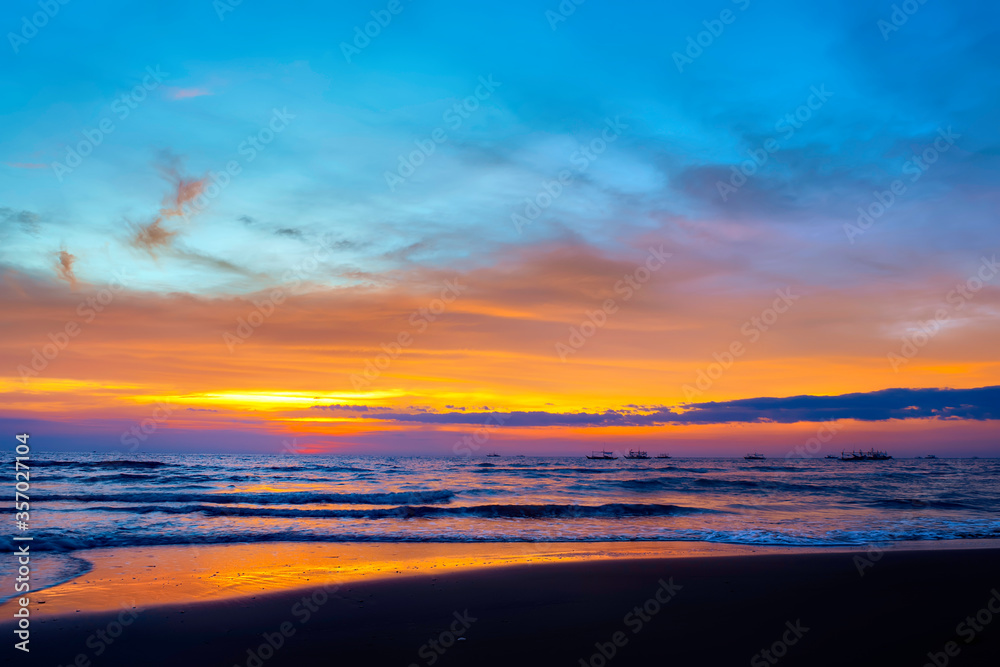Tropical sunset on cloudy sky with reflections in the ocean surface, Philippines