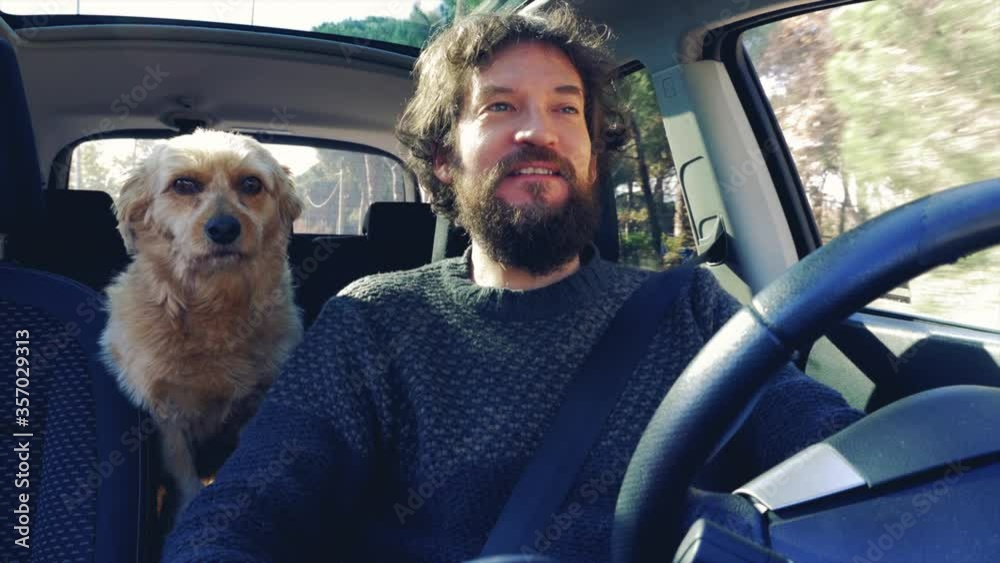 Happy man driving car talking to dog feeling free after end of corona virus