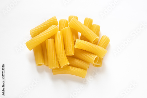 traditional italian pasta isolated on white background, heap of tortiglioni pasta, durum wheat noodles