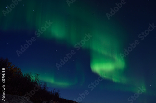 mighty aurora borealis dancing on late autumn night sky in the arctic circle © Arcticphotoworks