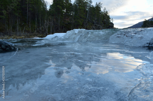cold frozen mountain creek with ice buildup