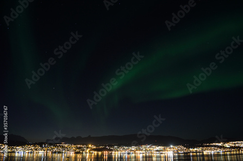 majestic aurora borealis dancing on night sky over the arctic circle city of tromsoe at dawn