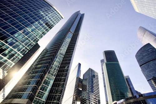 Office and residential skyscrapers on bright sun and clear blue sky background. Commercial real estate investment. Modern business city district. Office buildings. Financial city area. Downtown.