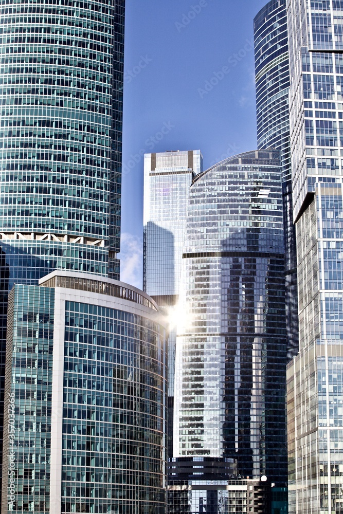 Office and residential skyscrapers on bright sun and clear blue sky background. Commercial real estate. Modern business city district. Office buildings exterior. Financial city district. Downtown. Office and residential skyscrapers on bright sun and clear blue sky background. Commercial real estate. Modern business city district. Office buildings exterior. Financial city district. Downtown.