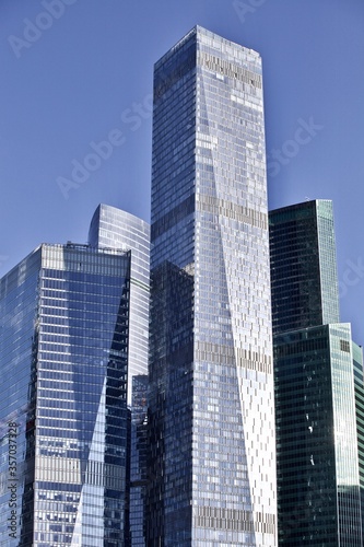 Office and residential skyscrapers on bright sun and clear blue sky background. Commercial real estate. Modern business city district. Office buildings exterior. Financial city district. Downtown. © ST-art