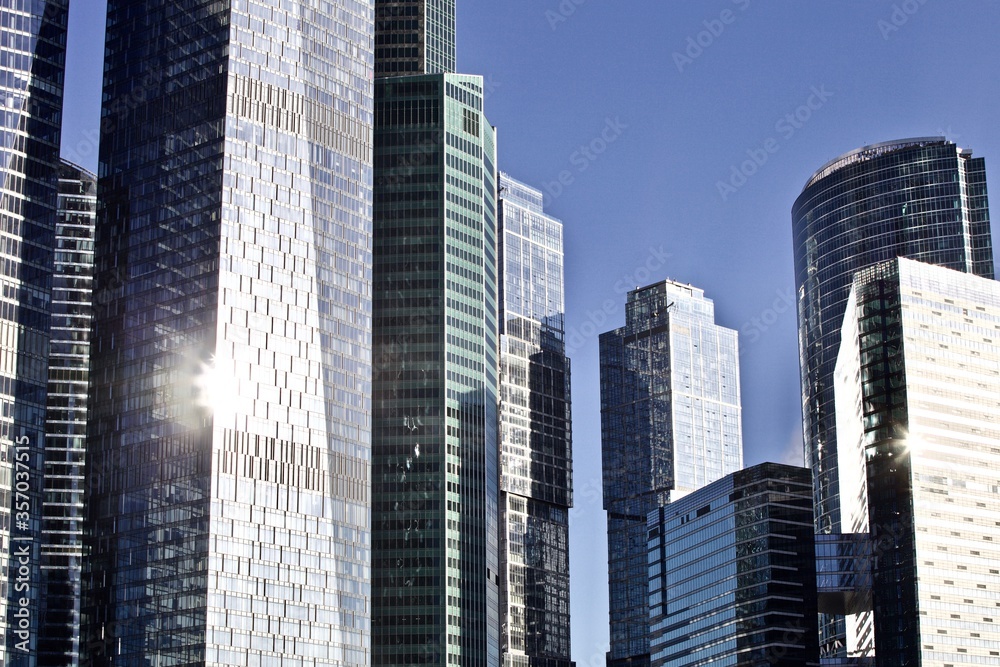 Office and residential skyscrapers on bright sun and clear blue sky background. Commercial real estate. Modern business city district. Office buildings exterior. Financial city district. Downtown.