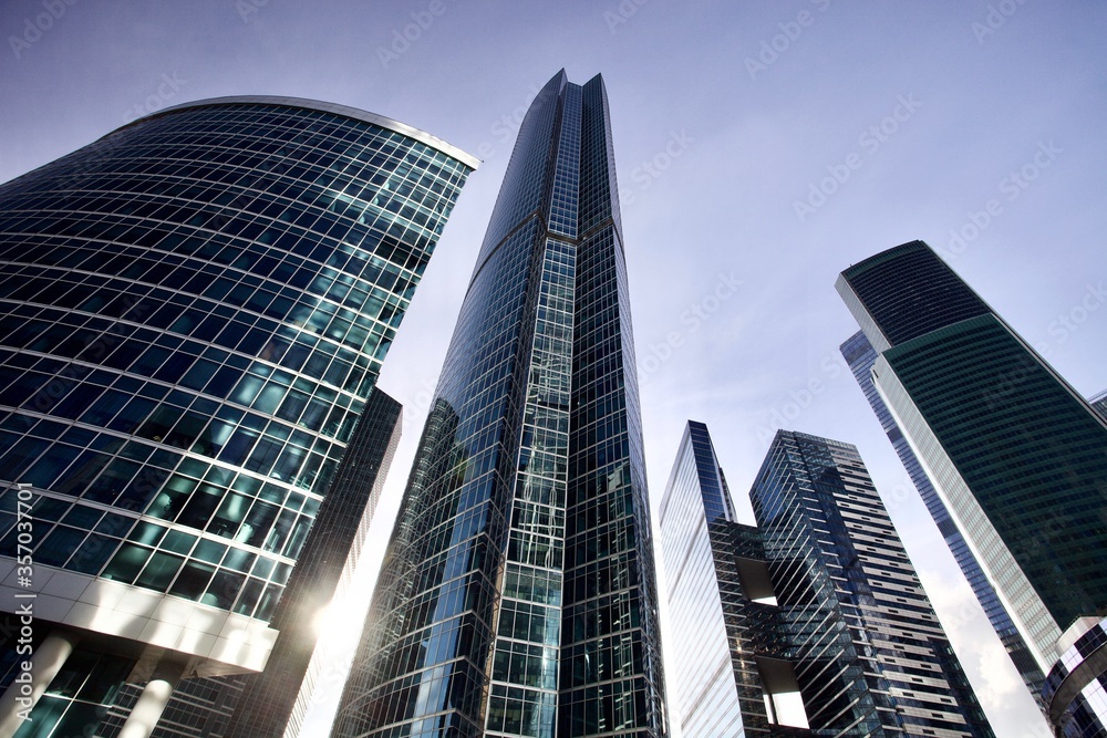 Office and residential skyscrapers on bright sun and clear blue sky background. Commercial real estate. Modern business city district. Office buildings exterior. Financial city district. City downtown