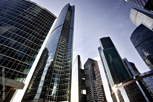 Office and residential skyscrapers on bright sun and clear blue sky background. Commercial real estate. Modern business city district. Office buildings exterior. Financial city district. Downtown.