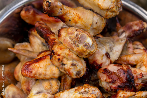 Juicy appetizing grilled chicken legs and wings. Close-up.
