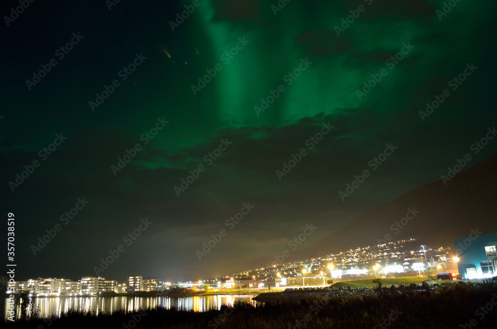 beautiful aurora borealis on the night sky over the mainland of tromsdalen