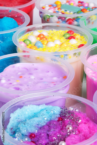 Various bows of colored slime with colorful dots over light gray background.