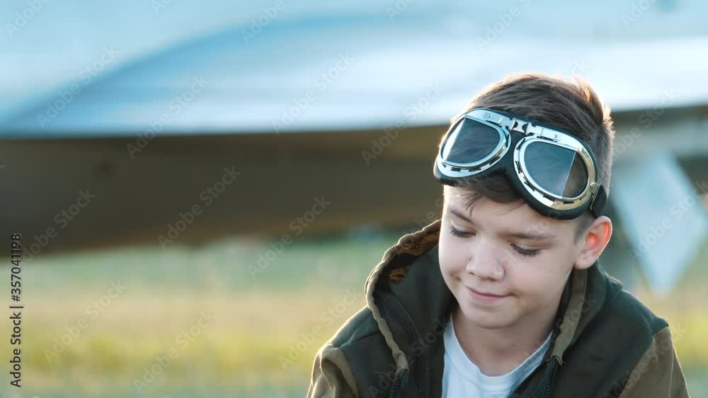 Face portrait of smiling child boy wearing pilot glasses looking at camera closeup. Imagination dream joy of flying, playful airplane fantasy, costume game in profession of little happy future aviator Face portrait of smiling child boy wearing pilot glasses looking at camera closeup. Imagination dream joy of flying, playful airplane fantasy, costume game in profession of little happy future aviator