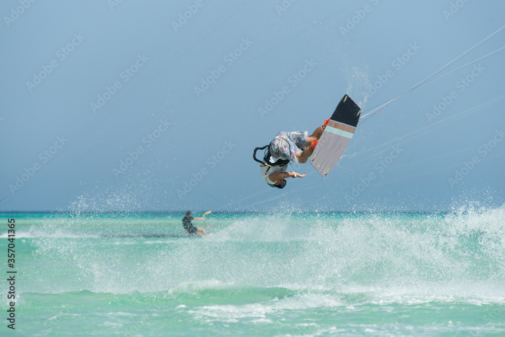 Fototapeta premium kiter does a difficult trick on a background of transparent water and blue sky