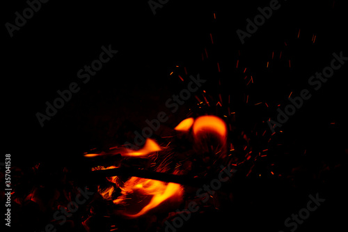 Bright orange fire with sparks. New year celebration. Concepts of cooking or fire event. Fire close up shot. Abstract background.  © Kateryna