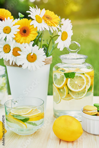 Lemonade and daisy flowers on table. Mason jar glass of lemonade with lemons. Cozy morning. Spring and summer season card. Healthy Food and Drink. Summer holidays. Outdoor picnic. Mother's day card