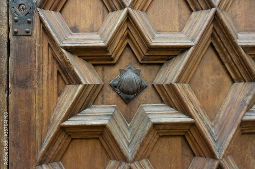 Fototapeta Naklejka Na Ścianę i Meble -  Vintage door handle. Shell door handle. Ancient door with very old and rusty door knob. Hexagram star wooden pattern.