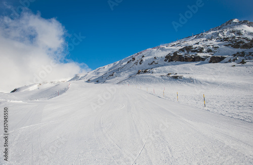Spring alp scenery from Molltal glacier. Ski slope with skier in fogge april day.
