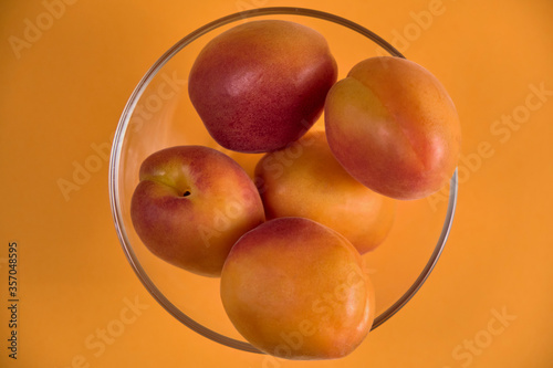 Fresh juicy apricots in a transparent glass plate. Macro.