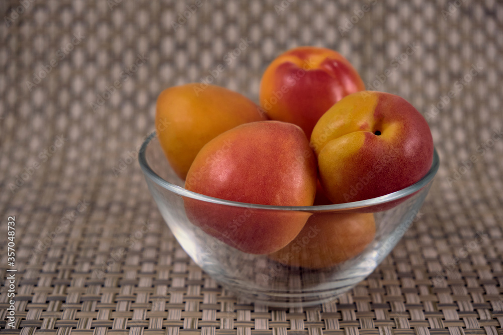 Fresh juicy apricots in a transparent glass plate. Macro. Fresh juicy apricots in a transparent glass plate. Macro.