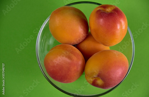 Fresh juicy apricots in a transparent glass plate. Macro.