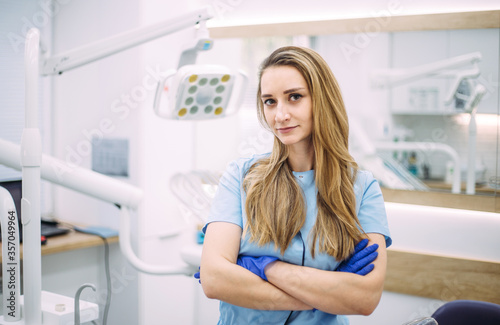 Portrait of female dentist. She standing in her dentist office.