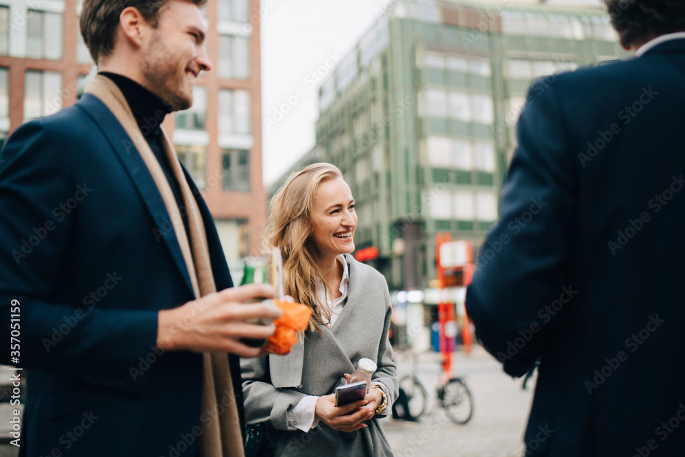 Smiling female entrepreneur with male colleagues in city Smiling female entrepreneur with male colleagues in city