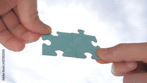 Man hands holding two pieces of puzzle. Finding the solution. Poblem solving background. Teamwork concept. Connection of jigsaw puzzles. Two pieces of puzzle join together. Perfectly fit to each other photo
