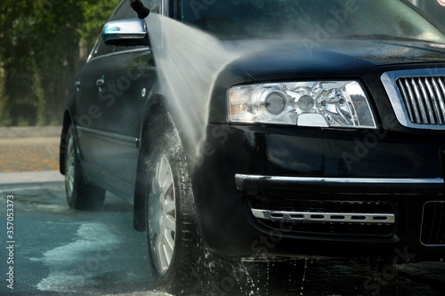 Car wash. Clear car concept. Wash black sedan