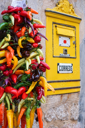 Old fashioned Spanish post box flanked by hanging pepper photo
