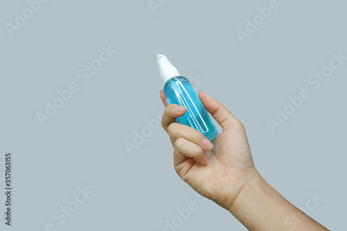 Asian woman's hand holding a sanitilizer with soft focus technique and clipping path