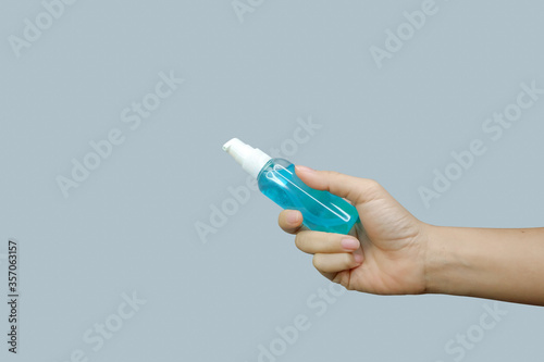 Asian woman's hand holding a sanitilizer with soft focus technique and clipping path