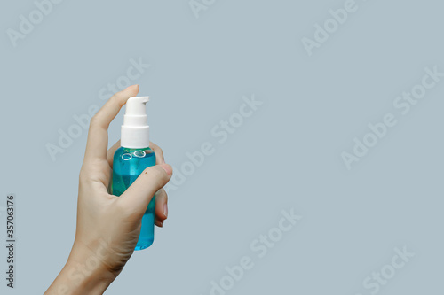 Asian woman's hand holding a sanitilizer with soft focus technique and clipping path