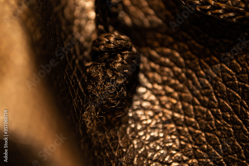 leather texture close up detail with warm lighting and soft focus background © archangelworks