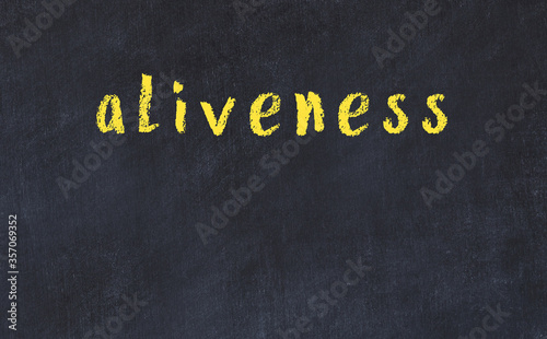 College chalk desk with the word aliveness written on in photo