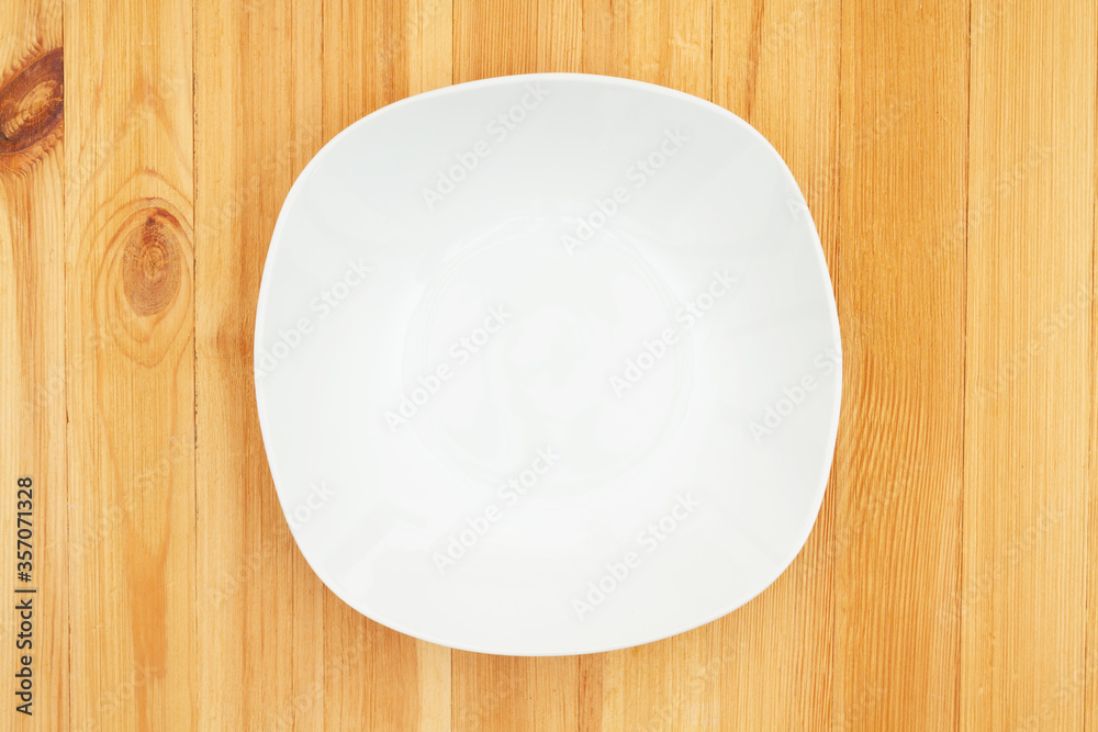 White empty plate on a wood table White empty plate on a wood table