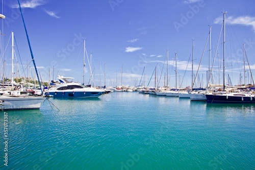 Yachts and speed boats at harbor. Yachts moored in the port. Ocean Coast pier. High class lifestyle. Yachting. Expensive toys. Sea ​​transport. Nautical. Yachting sport. Expensive yachts at the pier.