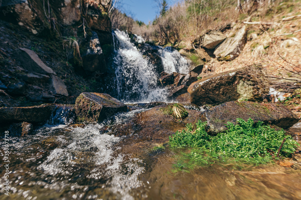 A waterfall with trees on the side of a mountain A waterfall with trees on the side of a mountain