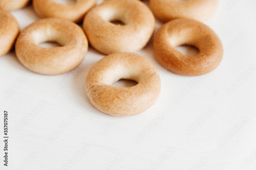 Drying or mini round bagels on a white wooden background. Copy, empty space for text
