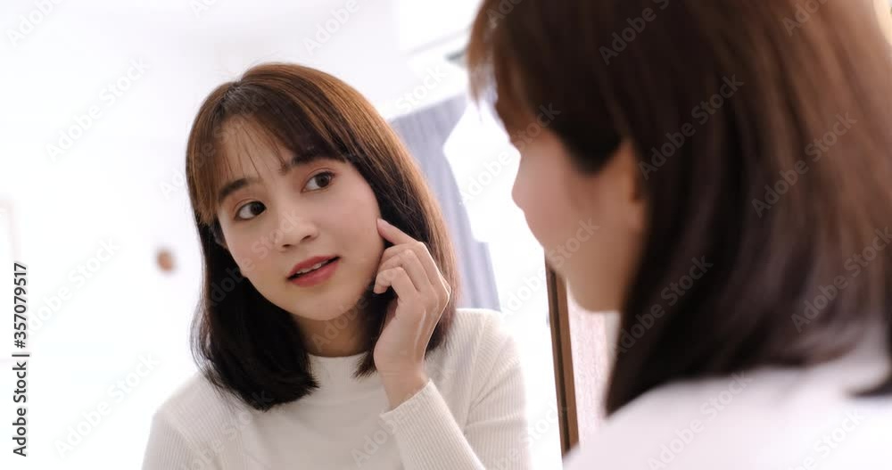 Asian woman checking face with mirror with clothes lifestyle at home Asian woman checking face with mirror with clothes lifestyle at home